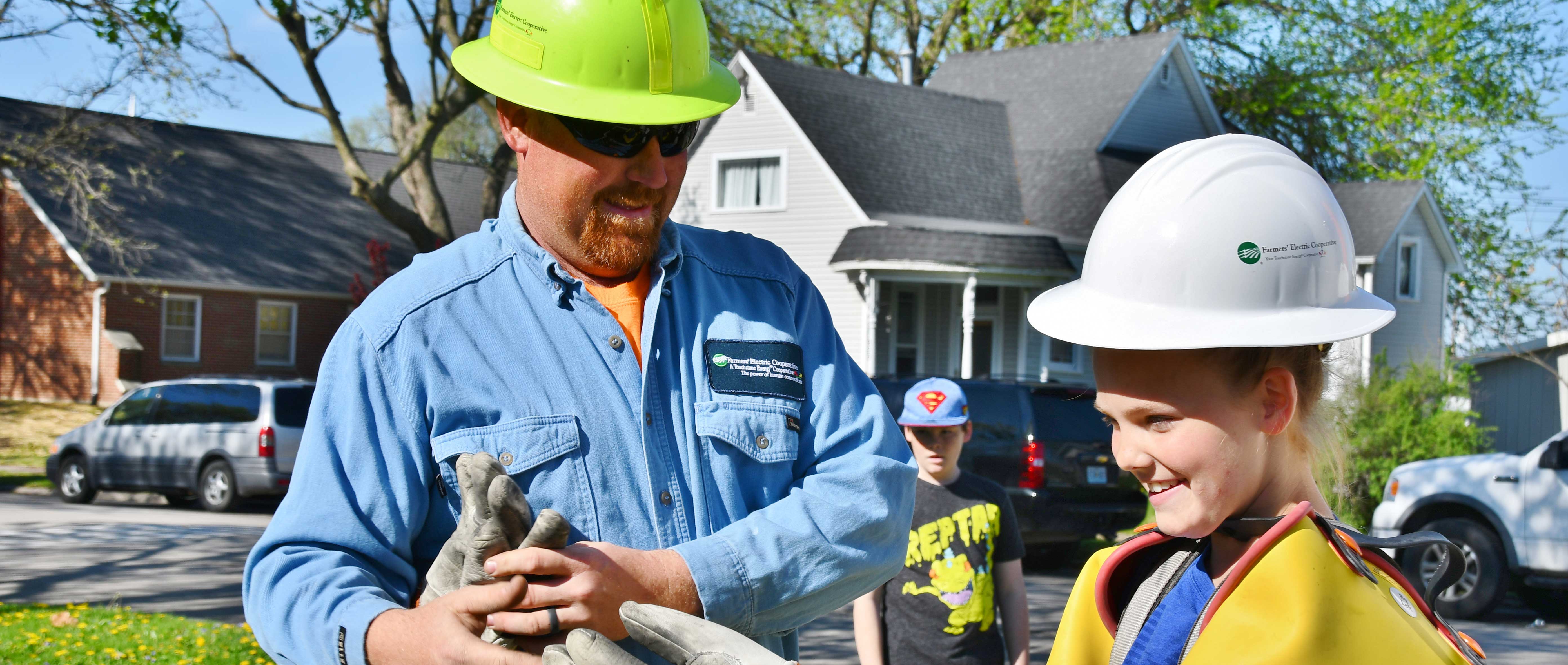 Lineman showing a student his safety gear